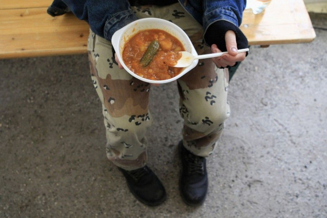 A young Hungarian man holds a dish in his hands at a soup kitchen where Hungarian Ecumenical Charity distributes free lunch to the needy ahead of iChristmas in Budapest, December 23, 2013.