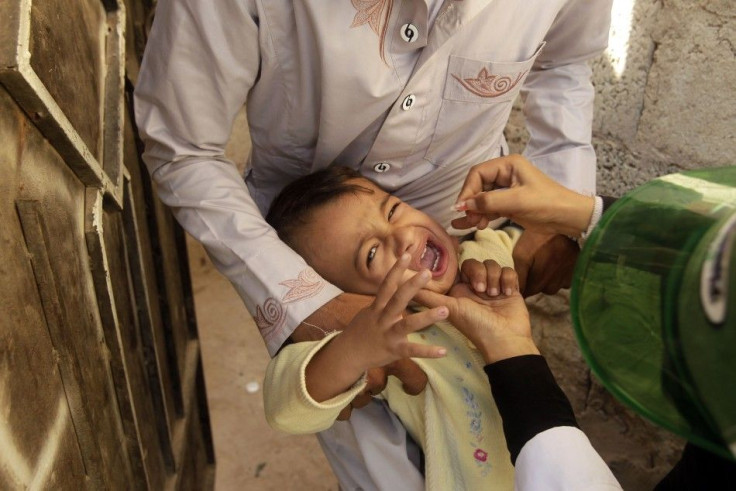 A boy cries as his father holds him still for a polio vaccination in Sanaa December 17, 2013, during a national campaign to vaccinate more than 4.7 million children across Yemen against polio. REUTERS/Khaled Abdullah