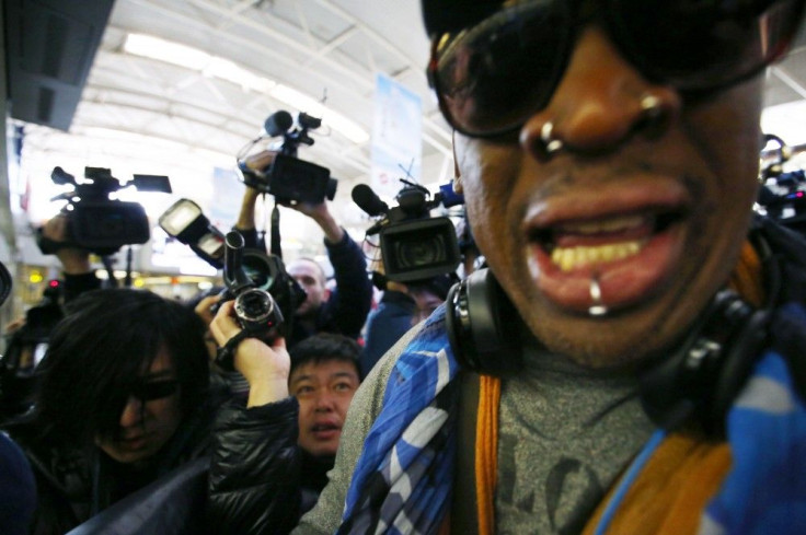 Former NBA basketball player Dennis Rodman is surrounded by the media at Beijing International Airport before he leaves for Pyongyang