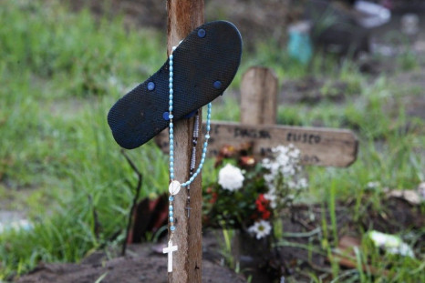 A slipper and rosary hang on an improvised marker for victims of super typhoon Haiyan at a mass grave site in front of a Catholic church in San Joaquin town of Palo, Leyte province, central Philippines December 23, 2013. Super typhoon Haiyan reduced almos