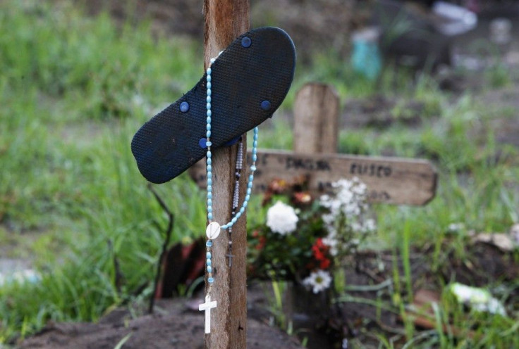 A slipper and rosary hang on an improvised marker for victims of super typhoon Haiyan at a mass grave site in front of a Catholic church in San Joaquin town of Palo, Leyte province, central Philippines December 23, 2013. Super typhoon Haiyan reduced almos