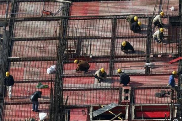 Labourers work at a construction site in Shanghai, January 16, 2014.