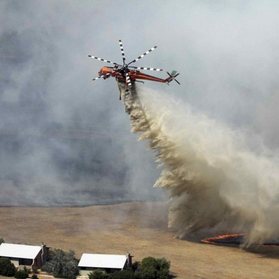 A helicopter dumps water on a bushfire burning near houses in the Grampians bushland in the southeastern Australian state of Victoria, about 300 km (186 miles) west of Melbourne, January 17, 2014
