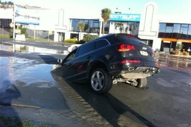 A car sinks into a hole caused by an earthquake in the southern New Zealand city of Christchurch June 13, 2011.
