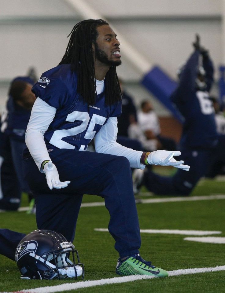 Seattle Seahawks defensive back Sherman sings while stretching with teammates before their NFL Super Bowl XLVIII football practice in East Rutherford