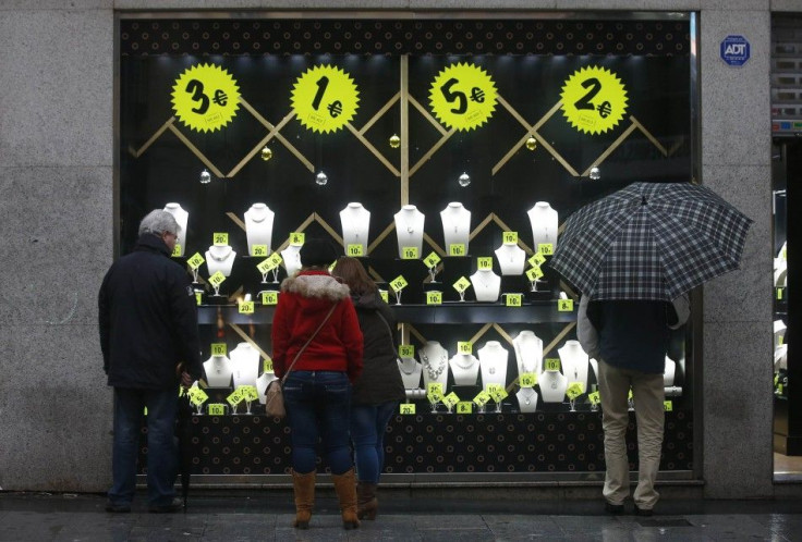 People look at a shop window selling accessories on sale in downtown Madrid December 19, 2013. Retailers in Europe are predicting their best Christmas since the financial crisis, though optimism is laced with caution in the face of rising e-commerce and e