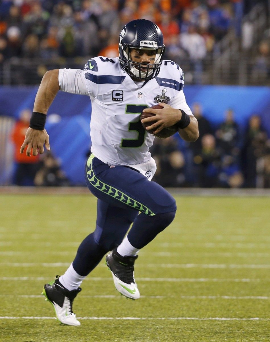 Seattle Seahawks quarterback Russell Wilson runs the ball against the Denver Broncos during the first half in the NFL Super Bowl XLVIII football game in East Rutherford