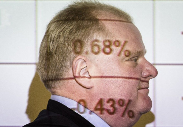 Toronto Mayor Rob Ford walks by a screen displaying budget numbers during a Capital and Operating Budgets meeting at City Hall in Toronto, January 22, 2014.