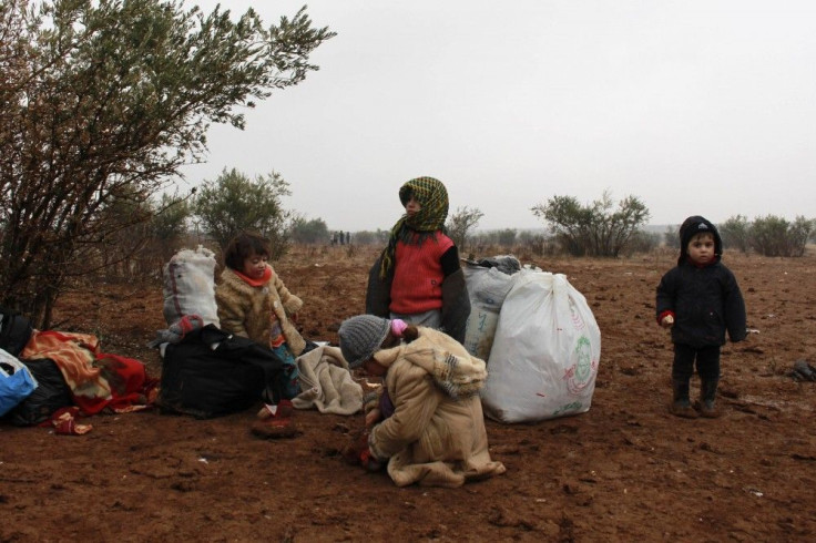 Syrian refugees wait to enter Turkey after fleeing violence in Syria on the Syrian-Turkish border in Shamm Alqrain village, northern countryside of Aleppo January 13, 2014.