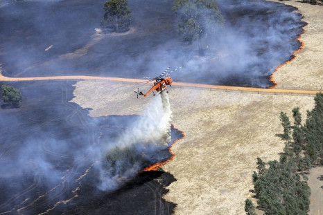 A helicopter dumps water on a bushfire burning in the Grampians bushland in the southeastern Australian state of Victoria