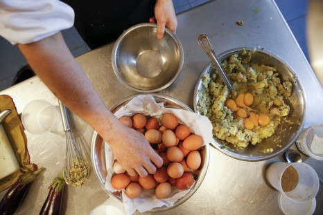 Castaneda, chef and owner of La Guayaba Verde restaurant grabs an egg as he prepares dishes at the restaurant's kitchen in Caracas