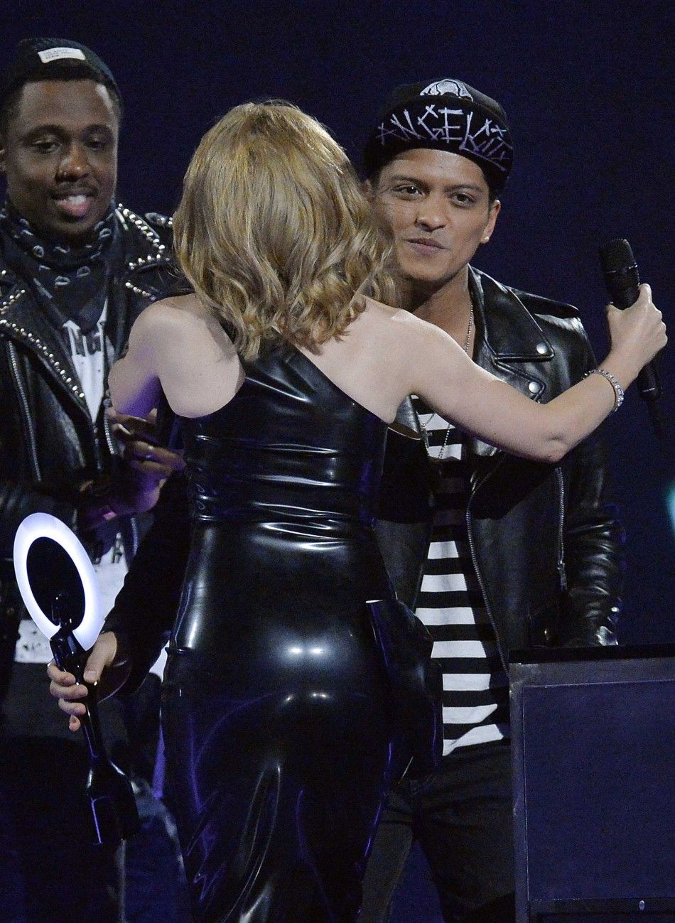Singer Minogue congratulates Bruno Mars after he won the International Male Solo Artist award at the BRIT Awards, celebrating British pop music, at the O2 Arena in London