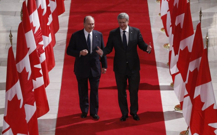 Canada's PM Harper walks with the Aga Khan in the Hall of Honour on Parliament Hill in Ottawa