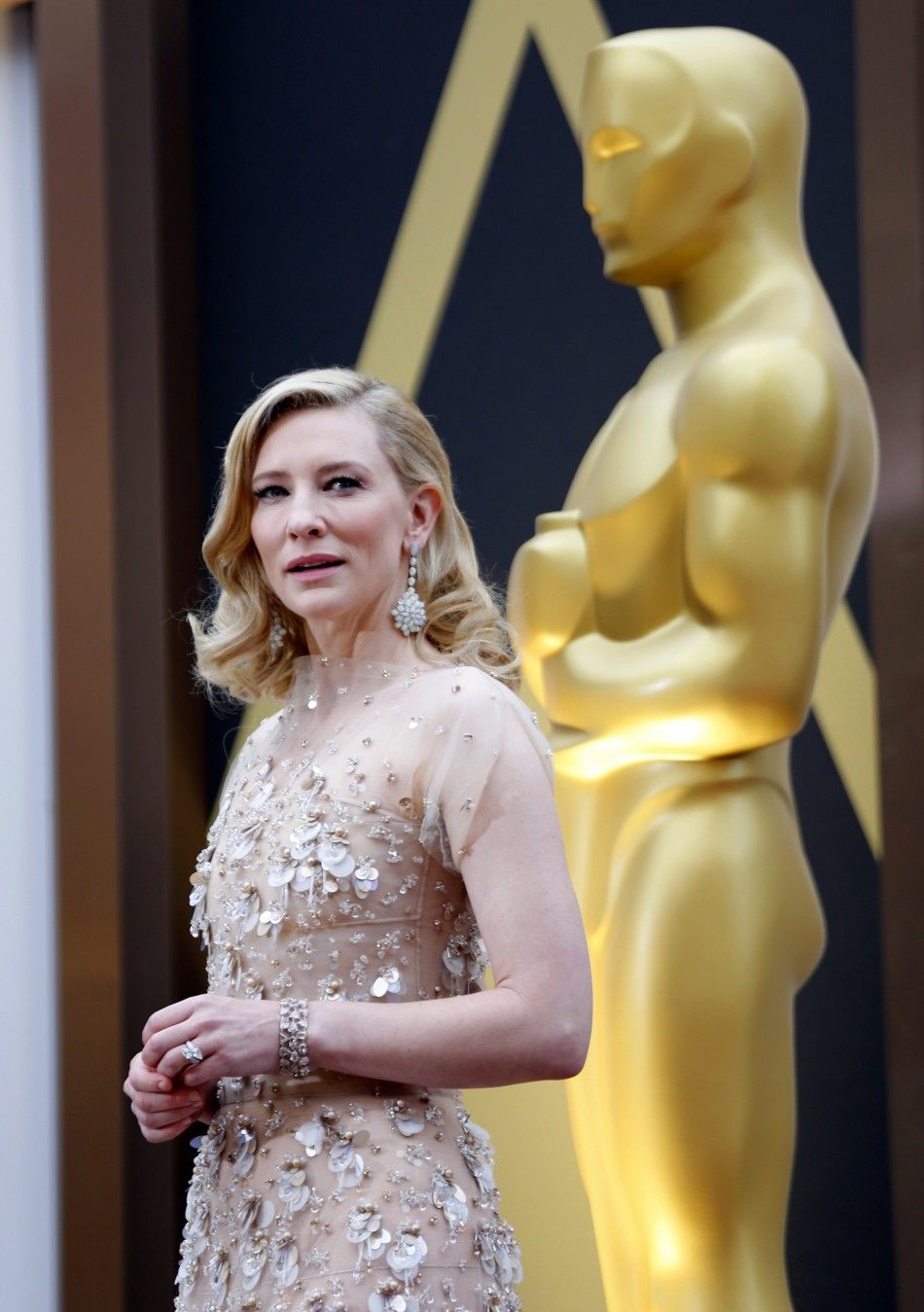 Cate Blanchett, best actress nominee for her role in quotBlue Jasmine,quot wears a nude Armani gown with metallic embellishments as she arrives at the 86th Academy Awards in Hollywood