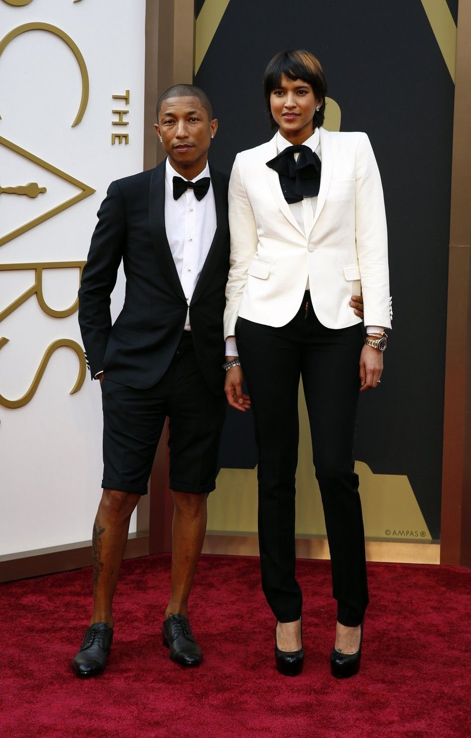Singer Pharrell WIlliams, wearing a Lanvin suit with shorts, arrives with wife, Helen Lasichanh, at the 86th Academy Awards in Hollywood