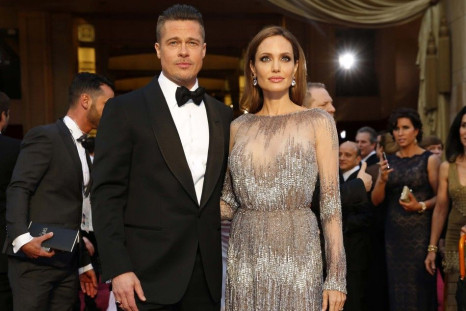 Actors Brad Pitt and Angelina Jolie, wearing a silver Elie Saab gown, arrive at the 86th Academy Awards in Hollywood