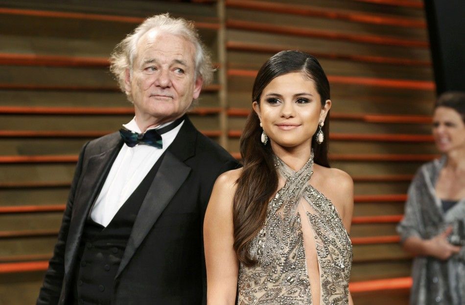 Actor Bill Murray quotphotobombsquot singer Selena Gomez as they arrive for the 2014 Vanity Fair Oscars Party in West Hollywood