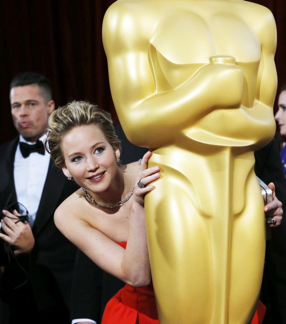 Jennifer Lawrencebest supporting actress nominee for her role in the film quotAmerican Hustlequot, peeks around an Oscar statue on the red carpet