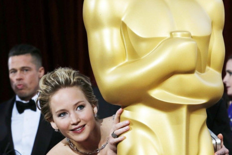 Jennifer Lawrencebest supporting actress nominee for her role in the film &quot;American Hustle&quot;, peeks around an Oscar statue on the red carpet