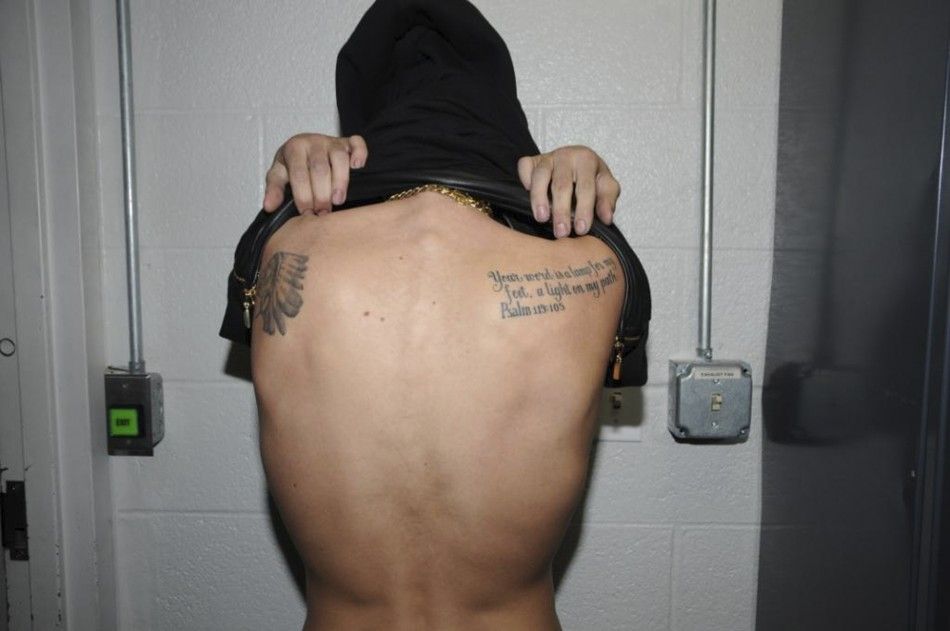 Canadian pop singer Justin Bieber shows a tattoo on his back while in police custody in Miami Beach, Florida January 23, 2014 in this Miami Beach Police Department handout released to Reuters on March 4, 2014. Bieber was charged with driving under the inf