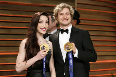 Ice dancers Meryl Davis and Charlie White hold up their gold medals as they arrive at the 2014 Vanity Fair Oscars Party in West Hollywood