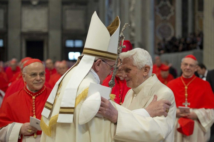 Pope Francis (L) greets Pope Emeritus Benedict XVI during a consistory ceremony in Saint Peter's Basilica at the Vatican February 22, 2014. Pope Francis urged 19 freshman cardinals to shun rivalries and factions at an induction ceremony on Saturday where