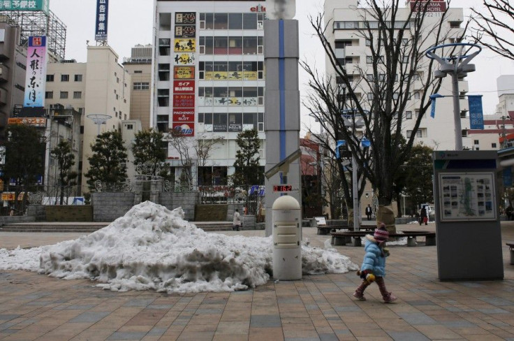 A child walks past a geiger counter, measuring a radiation level of 0.162 microsievert per hour, at a square in front of Koriyama Station in Koriyama, west of the tsunami-crippled Fukushima Daiichi nuclear power plant, Fukushima prefecture March 1, 2014. 
