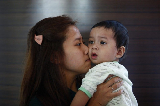 Erny Khairul, whose husband Mohd Khairul Amri Selamat was onboard the missing Malaysia Airlines flight MH370, kisses her daughter inside a hotel they are staying at in Putrajaya