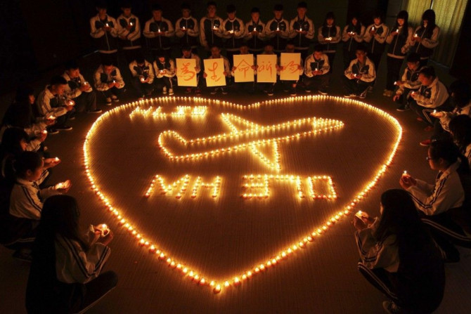 International school students light candles to pray for passengers aboard Malaysia Airlines flight MH370, in Zhuji