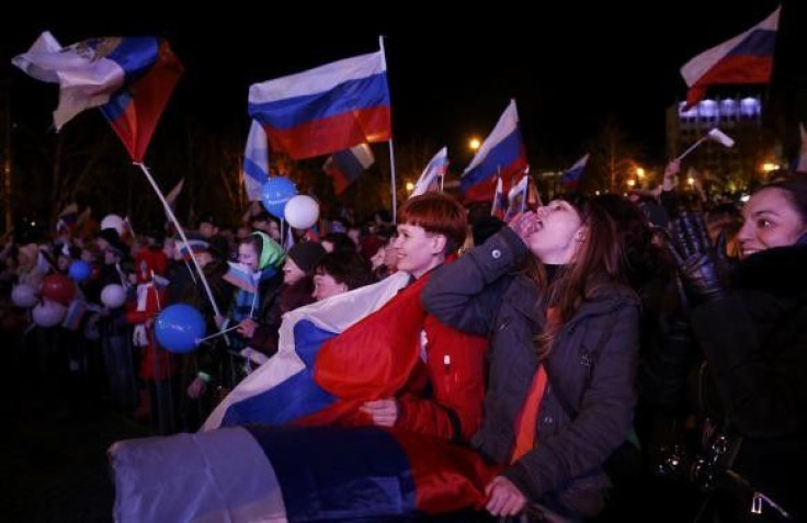People celebrate and wave Russian flags as the preliminary results of today&#039;s referendum are announced in the Crimean city of Sevastopol on 16 March, 2014.