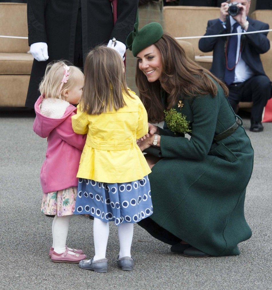 Britains Catherine, Duchess of Cambridge speaks to two girls during a visit with her husband, Prince William, to a St Patricks Day Parade at Mons Barracks in Aldershot
