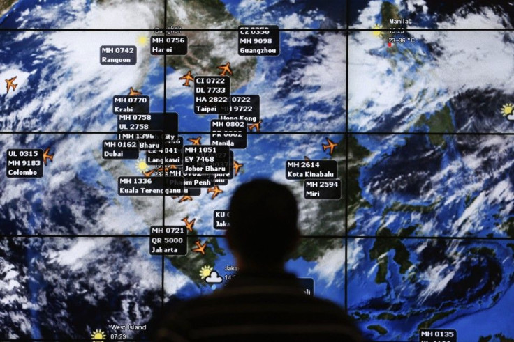 File photo shows a man watching a large screen showing different flights at the departure hall of Kuala Lumpur International Airport