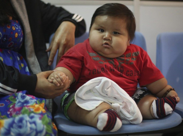 Eight-month-old Santiago Mendoza sits at a clinic for the obese in Bogota March 19 ,2014. Mendoza, who weighs 20 kg, will be put on a diet, therapist Salvador Palacios said. REUTERS/John Vizcaino