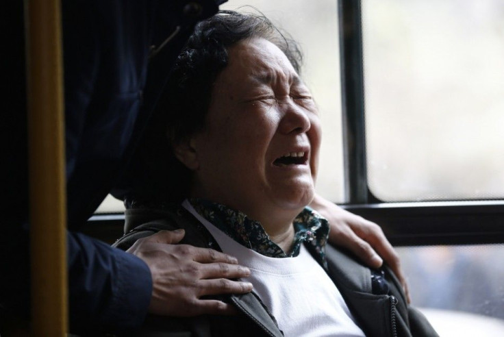 A family member of a passenger onboard Malaysia Airlines Flight MH370 cries on a bus before heading to the Malaysian embassy, outside Lido Hotel in Beijing, March 25, 2014. Bad weather and rough seas on Tuesday forced the suspension of the search for any 