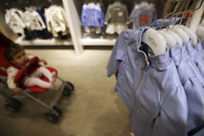 ATTENTION EDITORS: SPANISH LAW REQUIRES THAT THE FACES OF MINORS ARE MASKED IN PUBLICATIONS WITHIN SPAIN   A baby looks at clothes as her family shops at a Lefties store in Madrid March 14, 2014.  While Inditex&#039;s Zara and other brands have seen tepid