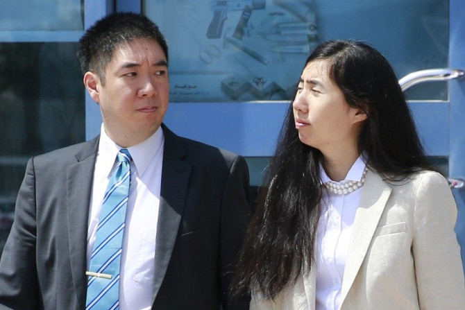 Matthew and Grace Huang, a U.S. couple who were accused of murdering their adopted daughter Gloria, stand outside the entrance of the Court of First Instance after their trial in Doha