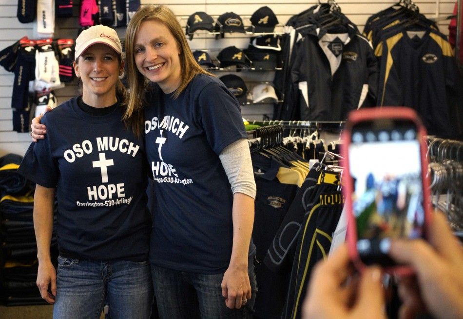 Women pose in the new Oso mudslide support t-shirts in the Action Sports shop in downtown Arlington, Washington