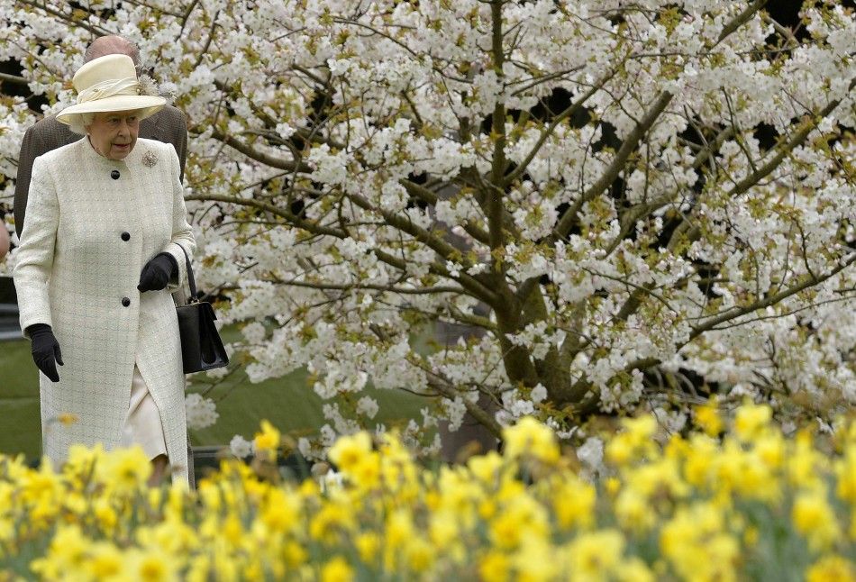 Britains Queen Elizabeth and Prince Philip walk amongst spring blossom and flowers as they arrive to attend the unveiling of the Windsor Greys statue in Windsor