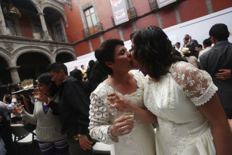 A lesbian couple kisses during a toast at a mass wedding in Mexico City