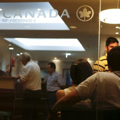 Customers wait their turn to be served at the Air Canada&#039;s office in Caracas