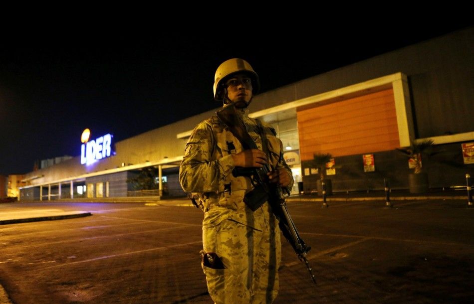 A soldier guards a supermarket to prevent looting after an earthquake and tsunami hit the northern port of Iquique April 2, 2014. Chilean authorities on Wednesday were assessing the damage from a massive earthquake that struck off the northern coast, caus