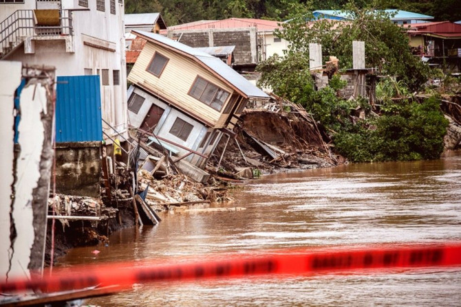 Houses can be seen falling into the Mataniko River as a result of severe flooding near the capital Honiara in the Solomon Islands in this picture released by World Vision April 6, 2014. Local media reported that the United Nations Office for the Coordinat