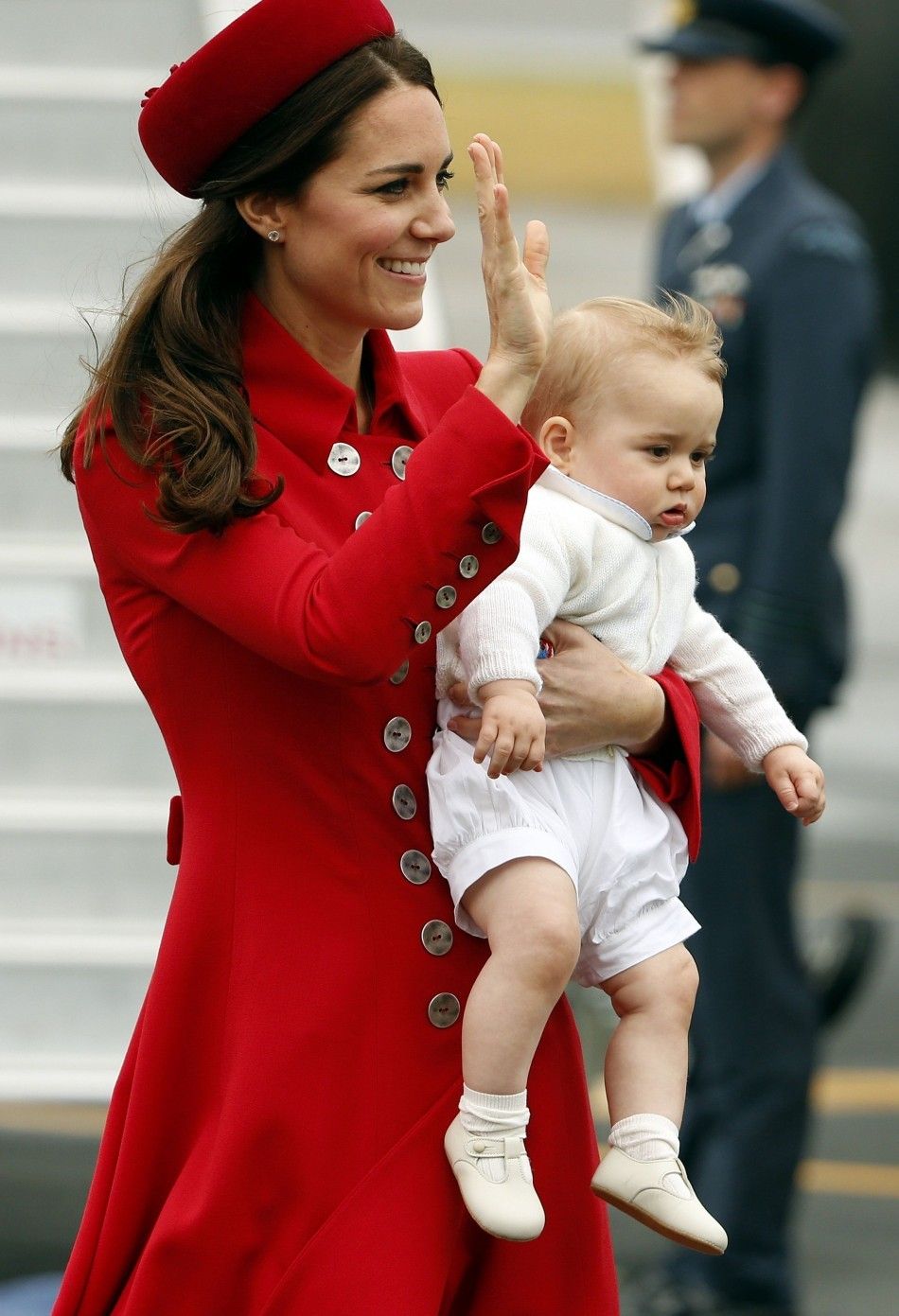 Catherine, the Duchess of Cambridge, holds her son Prince George after disembarking their plane with her husband Britains Prince William after arriving in Wellington