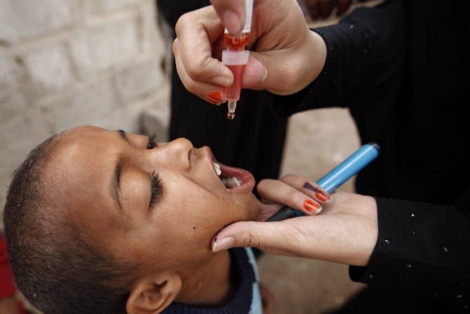 A health worker administers polio vaccine drops to a boy in an outskirt of the Yemeni capital Sanaa April 7, 2014. Yemen&#039;s Ministry of Public Health and Population launched a national polio immunization campaign on Monday, according to World Health O