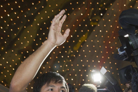 Boxer Manny Pacquiao of the Philippines waves to fans from a ring in the lobby of the MGM Grand Hotel and Casino in Las Vegas, Nevada April 8, 2014. Pacquiao will challenge undefeated WBO welterweight champion Timothy Bradley of the U.S. at the MGM Grand