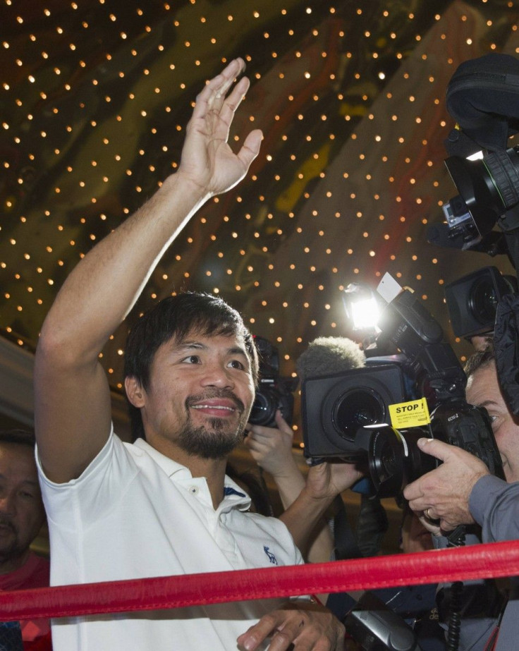 Boxer Manny Pacquiao of the Philippines waves to fans from a ring in the lobby of the MGM Grand Hotel and Casino in Las Vegas, Nevada April 8, 2014. Pacquiao will challenge undefeated WBO welterweight champion Timothy Bradley of the U.S. at the MGM Grand 