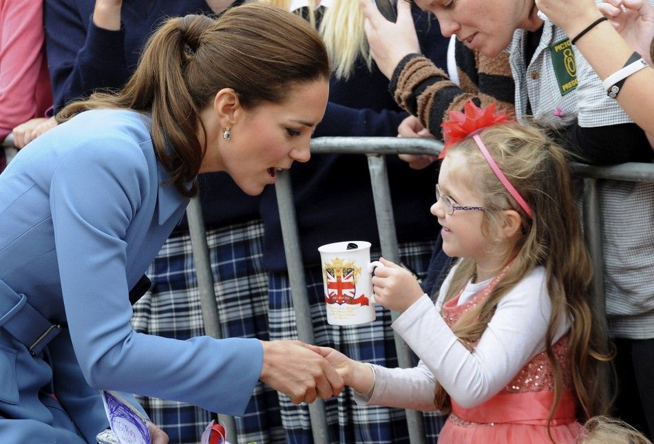 Catherine, the Duchess of Cambridge, reacts as she meets a young girl after laying a wreath with her husband, Britains Prince William, at the war memorial in Seymour Square