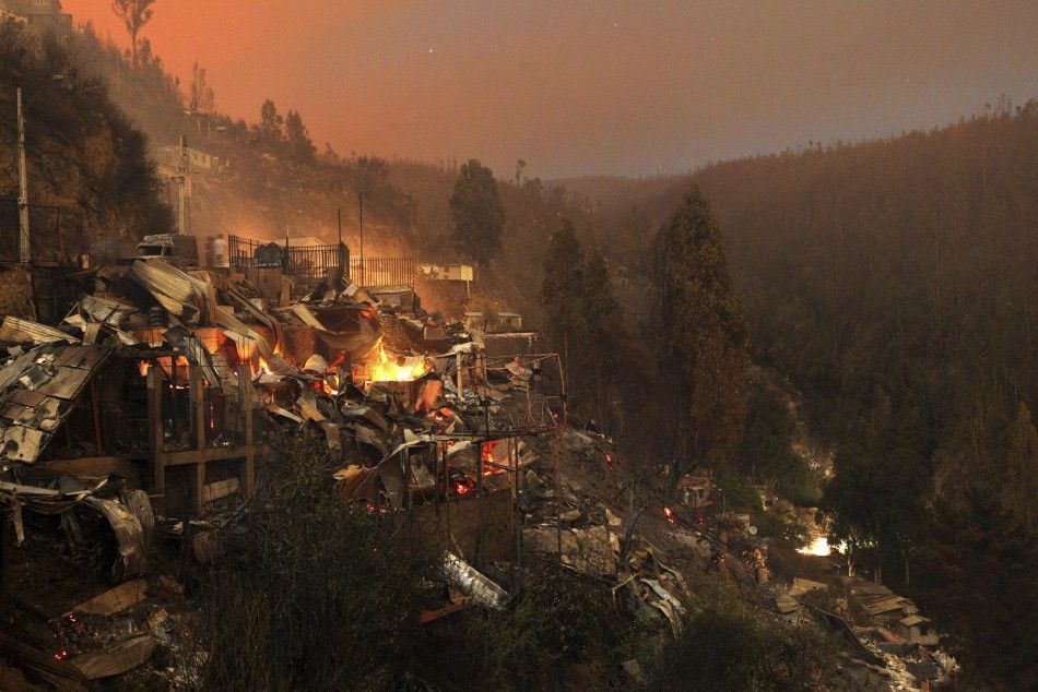 Destroyed houses are seen at the location where a forest fire burned several neighbourhoods in the hills in Valparaiso city, northwest of Santiago, April 13, 2014. At least 12 people were killed and 2,000 houses destroyed over the weekend by a fire that d