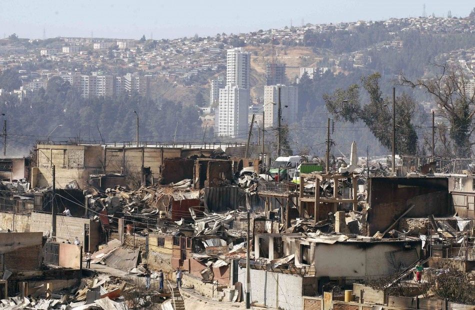 Destroyed houses are seen at the location where a forest fire burned several neighbourhoods in the hills in Valparaiso city, northwest of Santiago, April 13, 2014. At least 11 people were killed and 500 houses destroyed over the weekend by the fire that d