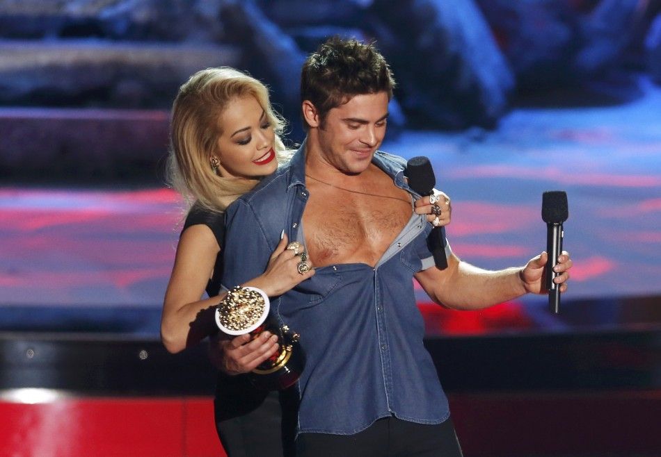 Zac Efron accepts the award for best shirtless performance for quotThat Awkward Momentquot as his shirt is ripped open by presenter Rita Ora at the 2014 MTV Movie Awards in Los Angeles